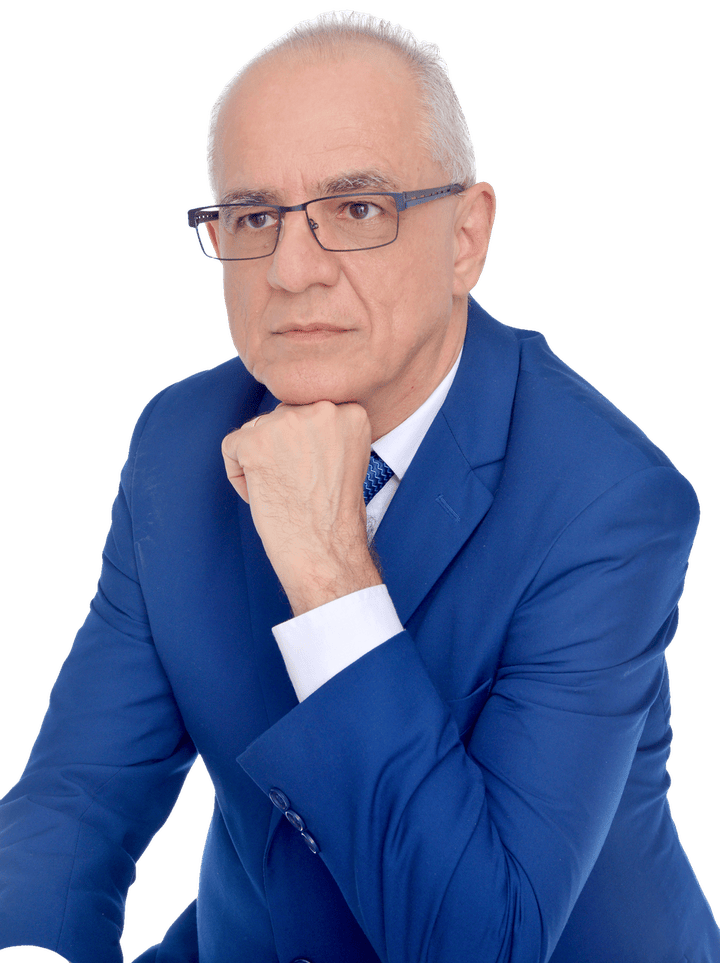 Alexandre Kaiê com a mão no queixo, olhar atento, de paletó azul e gravata